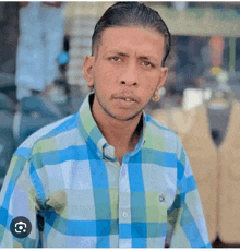 a man wearing a blue and green plaid shirt with a ck logo on it