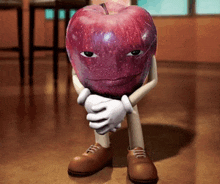 an apple with arms and legs is sitting on the floor