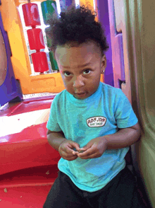 a young boy wearing a blue ron jay shirt