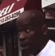 a man is standing in front of a store with a phone number on it