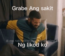 a man is sitting on a couch with his arms crossed and a caption that says grabe ang sakit