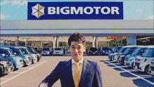 a man in front of a bigmotor sign