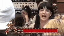 a woman is talking to a group of people while sitting at a table in a restaurant .