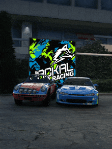 two racing cars are parked in front of a sign that says hackal racing