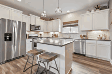 a kitchen with white cabinets stainless steel appliances and a stainless steel refrigerator