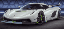 a white sports car with green wheels is parked in a dark room