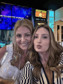 two women are posing for a picture in front of a screen that says ' we 'll leave the world '