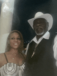 a man in a cowboy hat stands next to a woman