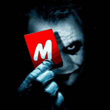 the joker is holding a red card with a letter m on it