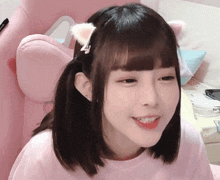 a girl wearing a cat ear headband and a pink shirt