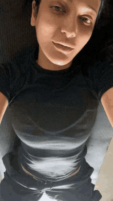 a woman in a black shirt is laying down on a yoga mat