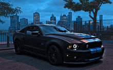 a black mustang is parked in front of a city at night