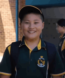 a young boy wearing a santa rosa shirt and hat smiles