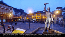 a statue of a man holding a bottle is in a square