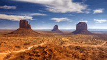 a desert landscape with a blue sky and clouds