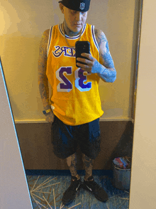 a man taking a picture of himself in a mirror wearing a yellow jersey with the number 33 on it