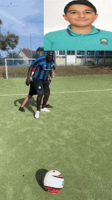 a boy in a blue shirt kicks a soccer ball on a field