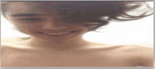 a blurred image of a shirtless man smiling with his eyes closed