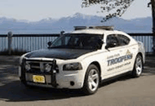 a white police car is parked on the side of the road .