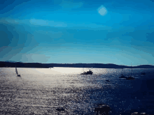 a large body of water with boats in it and mountains in the distance