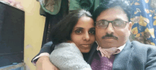 a man with glasses and a mustache is hugging a woman