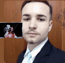 a man in a suit and tie is standing in front of a screen that says twitch