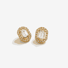 a pair of gold stud earrings with emerald cut stones and diamonds