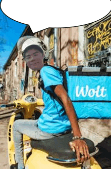 a man is sitting on a scooter with a blue bag that says wolt .