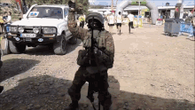 a man in a military uniform stands in front of a white truck with a license plate that says bc 32 lay