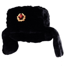 a black fur hat with a red star embroidered on it on a white background .