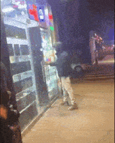 a man in a hooded jacket is standing in front of a store with a sign that says ' coca cola '