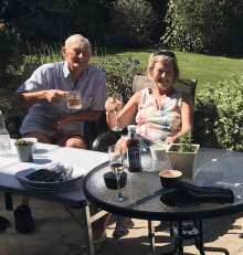 a man and a woman sitting at a table with a bottle of hp on it