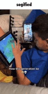 a boy is playing a video game on a tablet while another boy holds a cell phone in front of him