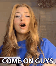 a woman in a blue shirt with the words come on guys on her face