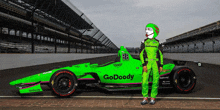 a green go doody race car is parked on the track