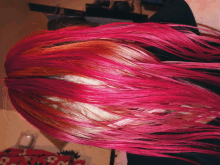 a close up of a person 's hair with pink and red highlights