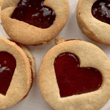 three heart shaped cookies with jam in them