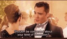 a man in a tuxedo is talking to a woman in a dress at a party .