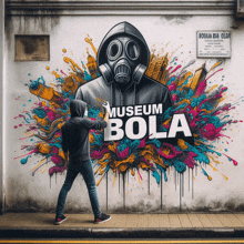 a man spray paints a mural on a wall that reads museum bola