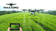 a person holding a tablet in front of a drone that says maxtorq aerospace