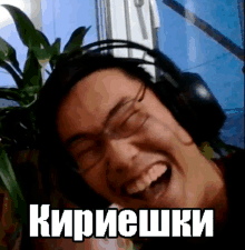 a man wearing headphones and glasses laughs with the word кирешки on the bottom right