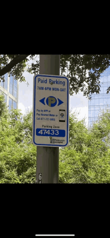 a sign on a pole says paid parking 7 am-6pm mon-sat