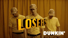 three men wearing yellow shirts and hats with the words losers dunkin ' on the bottom