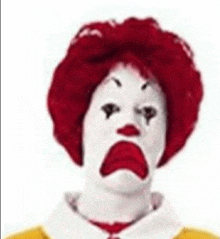 a mcdonald 's clown with red hair and a yellow shirt