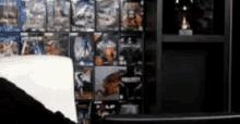 a blurred image of a person sitting in front of a shelf full of video games