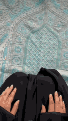 a woman is kneeling down on a prayer mat .