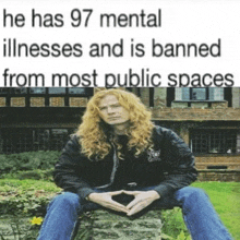 a man with long red hair is sitting on a rock in front of a building with a caption that says he has 97 mental