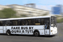 a white bus with fake bus by guru & tuti written on the side