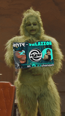 a grinch is holding a sign that says hype-blazzor on it