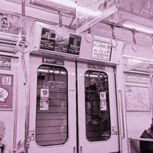 a black and white photo of a subway car with a man sitting on the train .